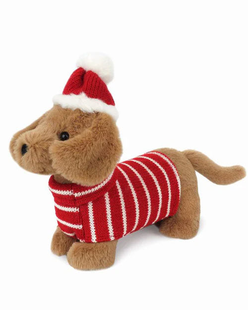 A plush toy dog wearing a festive red and white striped sweater and a matching red knit hat with a white pom-pom on top. The toy has a soft, light brown fur and is positioned standing on all four legs.