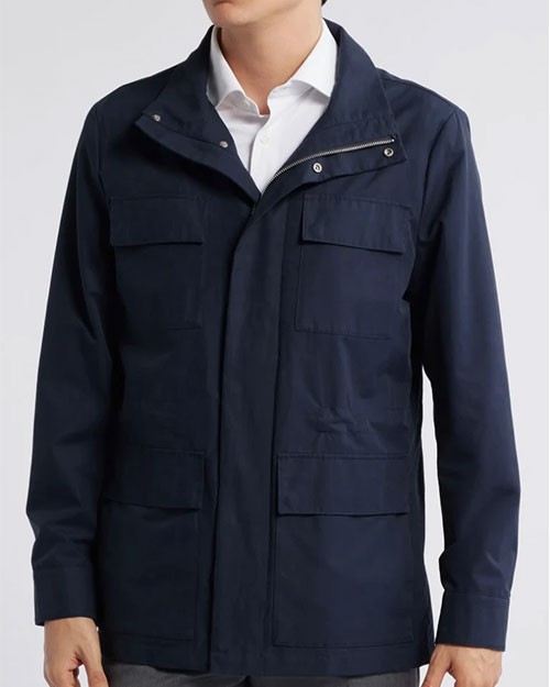 Person wearing a navy field jacket over a white button‑down shirt.