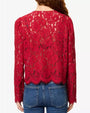 Red floral lace cardigan-style top with a round neckline, button-front closure, and scalloped hem, paired with blue jeans against a light gray background.