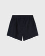 Dark navy linen shorts with an elastic waistband and a single button detail at the front, displayed against a light gray background.