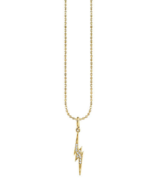 Gold necklace with a lightning bolt pendant encrusted with small clear gemstones, hanging from a delicate chain of round links.