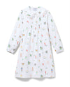 White long-sleeved dress with a Peter Pan collar, lace trim, and front pleats, decorated with colorful, whimsical illustrations of birds, people, trees, and other nature-inspired elements.