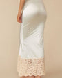 Back view of a person shown from the mid‑torso to the ankles is wearing a long, pale mint satin skirt. The skirt has a smooth, slightly glossy finish and a fitted silhouette that flares subtly toward the hem. The bottom portion features a wide band of cream-colored floral lace extending upward from the edge, adding contrast and texture.
