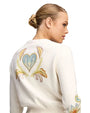 Back view of a cream knit cardigan featuring a large heart-shaped floral embroidery with multicolor detailing, long sleeves, and a fitted hem.