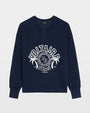 A navy blue long‑sleeve sweatshirt featuring a split crew neckline and a large printed graphic on the front. The design includes the text “VOLTAIRE PARIS” in bold white letters arranged in an arc, a circular emblem with additional lettering, two stylized palm trees, and small text reading “Est. 1997” and “art is truth.” The sweatshirt has a relaxed fit and a ribbed hem and cuffs.