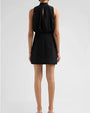 Black sleeveless mini dress with a gathered high neckline, back keyhole opening, and fitted skirt, shown from the rear.