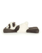 Plush toy shaped like a panda bear lying on its stomach with head turned to the side, featuring black and white fur, black ears, eye patches, arms, and legs, and a soft, fluffy white body.