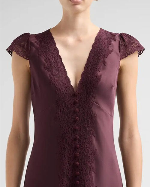 Close-up view of a plum-colored satin dress featuring a deep V-neckline trimmed with floral lace. The dress has delicate lace cap sleeves, a row of fabric-covered buttons down the center front, and lace detailing running along the button placket. The fitted bodice is shown from the shoulders to the waist against a light gray background.