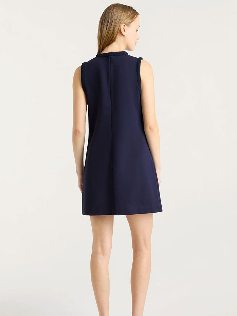 Back view of a sleeveless navy shift dress with a straight silhouette and a hidden back zipper.