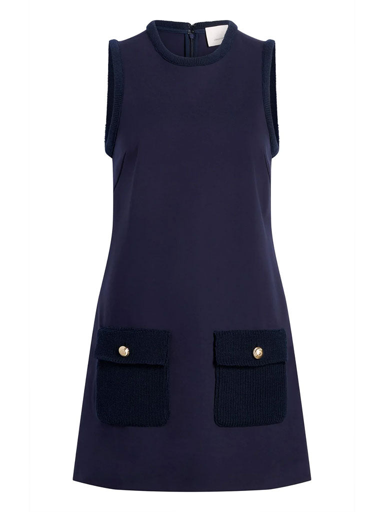 Sleeveless navy shift dress with a round neckline and two front flap pockets with gold button details.