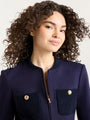 Navy textured jacket with a round collar, gold zipper, and two front knit patch pockets with gold button details.