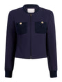 Navy zip‑front jacket with a round collar, long sleeves, and two textured knit patch pockets accented by gold buttons.