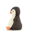 Plush penguin toy sitting upright and facing left, with dark grey fur on its body, a white belly and face, and orange beak and feet.