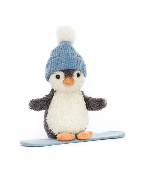 Plush toy penguin with a white belly, orange beak and feet, wearing a blue knit hat with a white pom-pom, standing on a light blue snowboard.