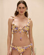 Person wearing a yellow ruffle bikini with purple floral print.