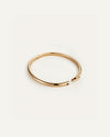 A polished gold bangle bracelet with a minimalist design, featuring a hinged opening and engraved with the brand name ‘Jenny Bird’ on the inner side.