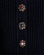 Close-up of decorative jeweled buttons on a navy knit sweater.