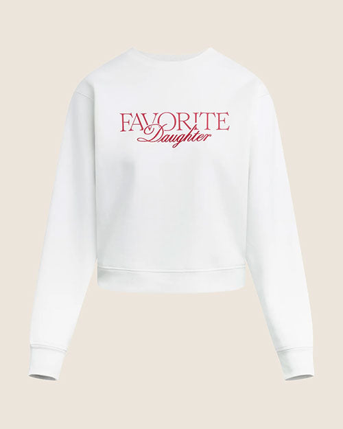 Product image of a white-colored cropped sweatshirt with a crew neckline, long sleeves, and ribbed cuffs and hem. The sweatshirt features the text “FAVORITE Daughter” printed across the chest in red lettering and is shown laid flat against a light neutral background.