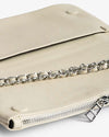 Close-up of a beige leather handbag with a silver zipper and a silver chain strap partially visible on top.