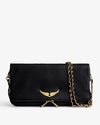 Black leather clutch bag with a gold wing emblem on the front flap, featuring a gold chain strap and zipper detail, displayed against a light background.