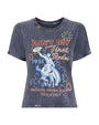 Front view of a faded black short-sleeve graphic T-shirt featuring a colorful rodeo-themed design. The artwork includes a cowboy riding a bucking horse in blue tones, surrounded by decorative circular patterns. Text on the shirt reads ‘Ain’t My First Rodeo,’ ‘1935,’ and ‘Diamond Cross Ranch cinq à sept’ in red, yellow, and white lettering.