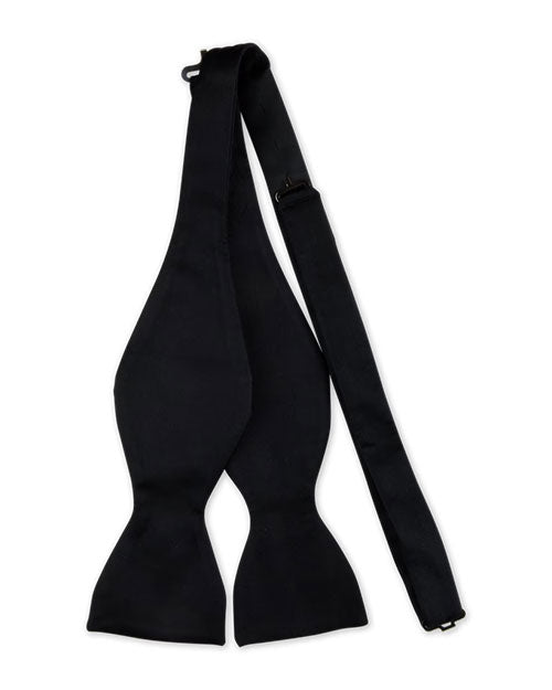 Black self-tie bow tie laid flat, showing its classic shape with wide ends tapering into narrow sections, designed for manual tying.