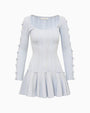 Light blue long-sleeve knit mini dress with a scoop neckline, fitted bodice, and flared hem. The sleeves feature multiple oval cutouts tied with small bows along the arms, and small bow accents are placed at the waistline above the skirt.