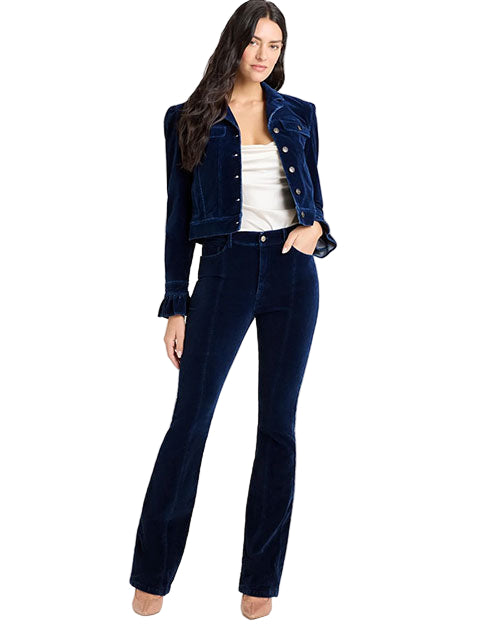 Front view of a person wearing a dark blue velvet jacket with button closure and ruffled cuffs, paired with matching high-waisted velvet pants and a white strapless top.