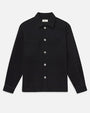 A black button-front overshirt jacket with a pointed collar, white contrast buttons, and two large chest patch pockets.