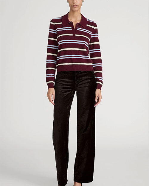 Model wearing a burgundy and white striped collared knit sweater paired with brown wide-leg pants.