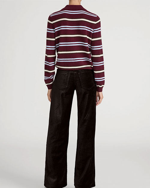 Model wearing a burgundy and white striped collared knit sweater paired with black wide-leg pants.