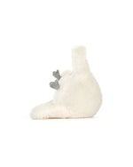 Plush toy resembling a white bird lying on its back with a fluffy, round body, one visible wing, and two small grey feet sticking up in the air.