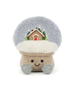 Plush toy shaped like a mushroom with a fluffy light gray cap featuring an embroidered snowy cabin scene, a burlap-textured stem, two light blue feet, and a smiling face with black eyes.