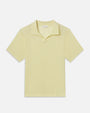 Product image of a pale yellow short-sleeve polo shirt displayed flat against a light background, featuring a soft collar, an open neckline without visible buttons, and a clean, minimal silhouette with a relaxed fit.