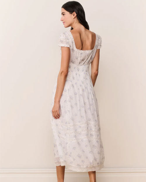Back view of a white ankle-length dress with short puff sleeves, lace trim, and a subtle floral pattern.
