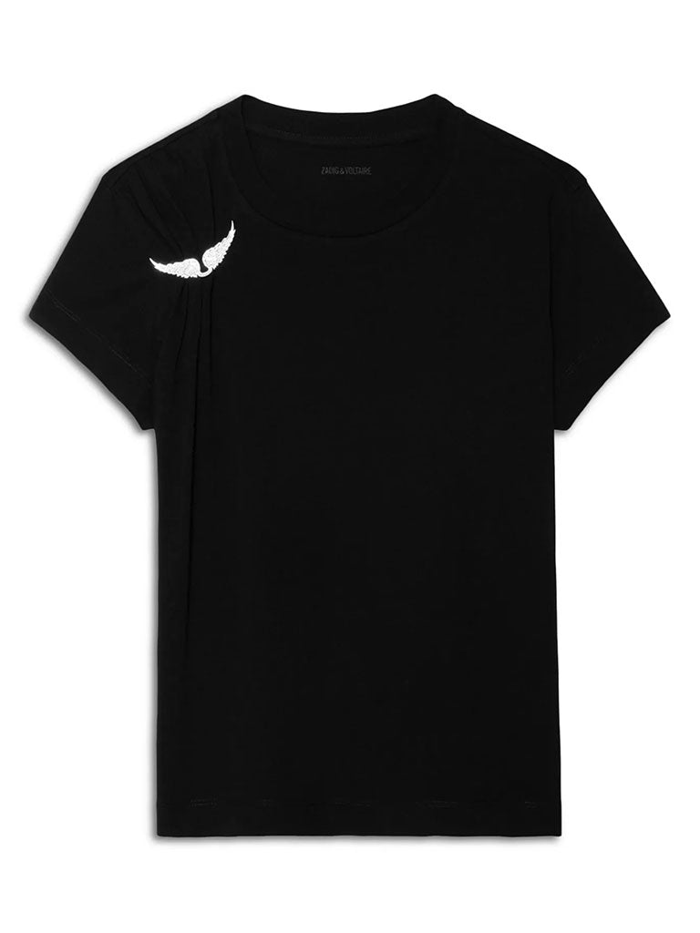 A black short‑sleeve t‑shirt featuring a small white winged brooch near the left shoulder.