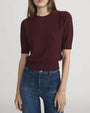 Front view of a short-sleeve textured knit top in deep burgundy with a ribbed hem and crew neckline, paired with high-waisted blue jeans.