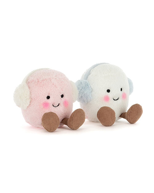 Two round plush toys with smiling faces and earmuffs—one pink with white earmuffs, the other white with light blue earmuffs—both featuring black eyes, rosy cheeks, and brown feet.