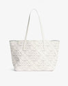White leather tote bag with a perforated geometric pattern, featuring two long shoulder straps and a structured rectangular shape, displayed against a plain white background.
