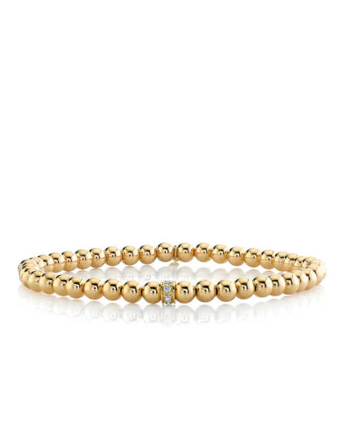 Gold beaded bracelet on a white background