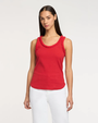 Woman wearing a red sleeveless top with braid details on a white background