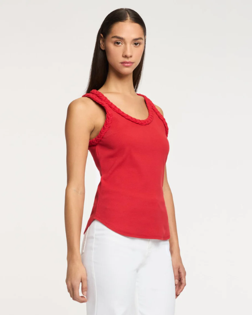Woman wearing a red sleeveless top with braided details on a white background