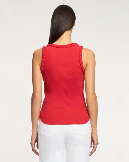 Woman wearing a red sleeveless top with braid details on a white background