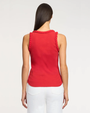 Woman wearing a red sleeveless top with braid details on a white background