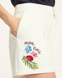 White shorts with floral embroidery and 'mon ami' text on a white background