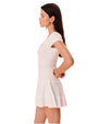 A sideview of a brunette model with her hands on her hips, wearing large gold hoops and dressed in a stylish white and blue thinly striped dress, with a lightly ruffled skirt.