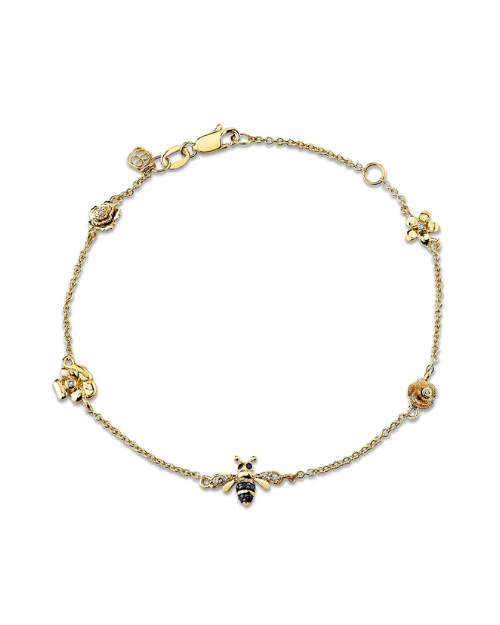 Gold bracelet with bee and flower designs on a white background