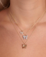 Gold bow necklaces on a person's neck