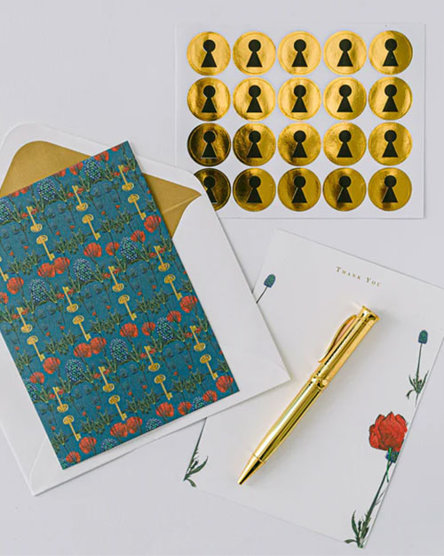 A gold pen, gold foil stickers, and a card from Good Juju Ink's Enchanted Garden Lux Thank You stationery set.