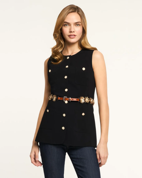 Woman wearing a black sleeveless top with buttons and jeans on a white background